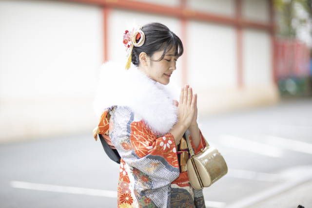 神社で願い事をする女性