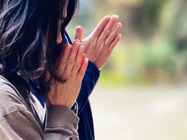 神社で参拝する男女